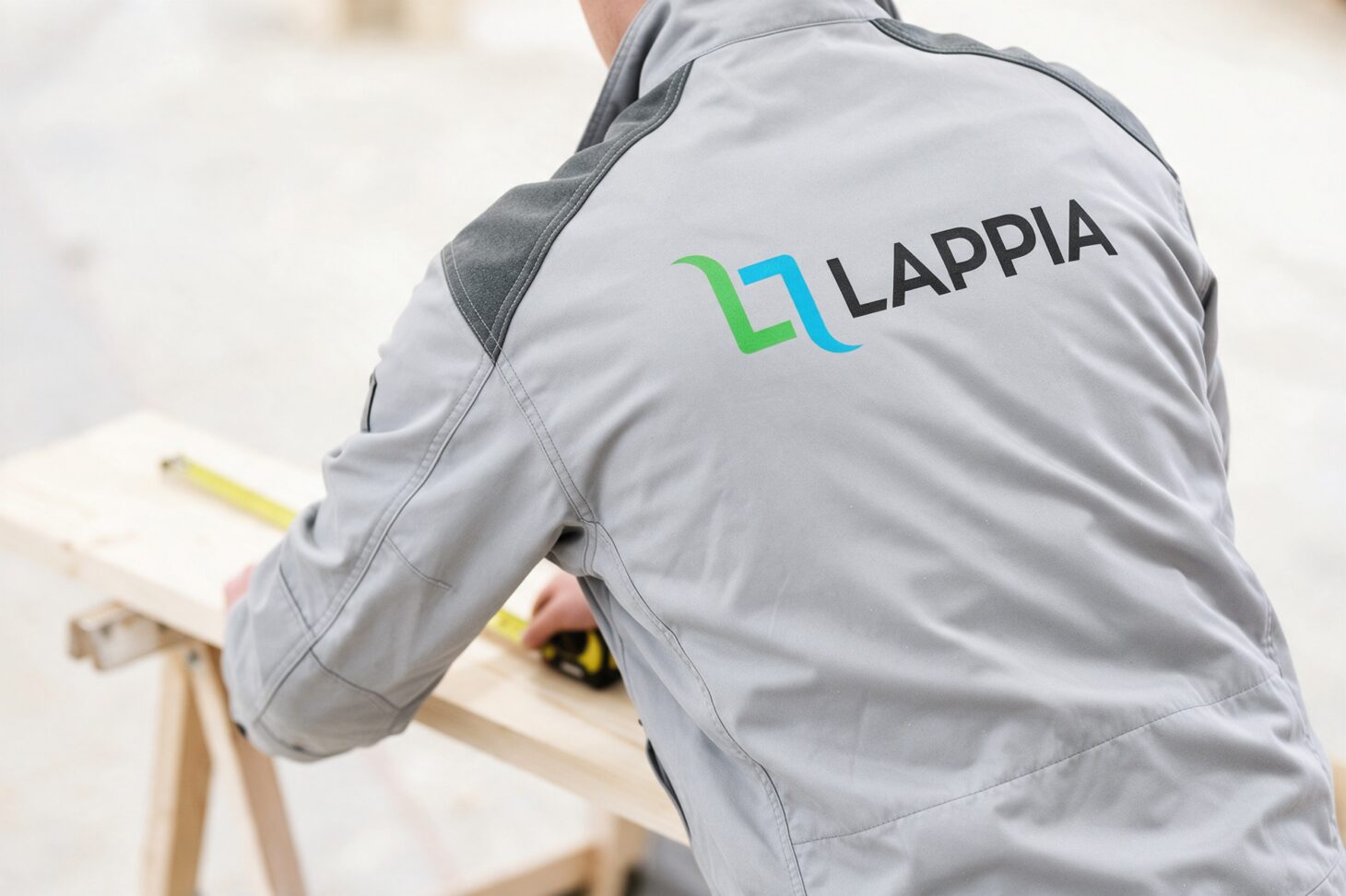 Lappian logo työtakin selässä opiskelijan mitatessa lautaa