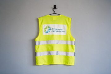Keminmaan Energian ja Veden logo keltaisen huomioliivin selässä