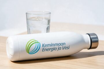 Keminmaan Energian ja Veden logo valkoisessa juomapullossa vesilasin vieressä