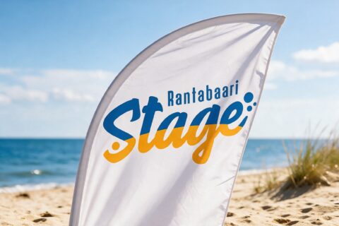 Rantabaari Stagen logo valkoisessa rantalipussa hiekkarannalla meren äärellä