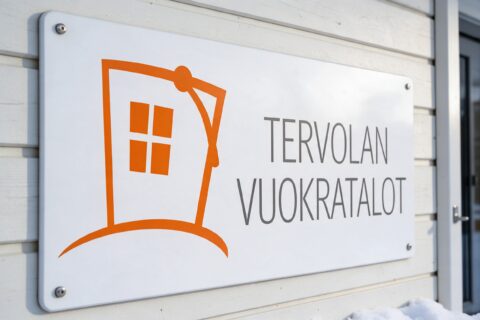 Tervolan Vuokratalojen logo kyltissä talon ulko-oven vieressä