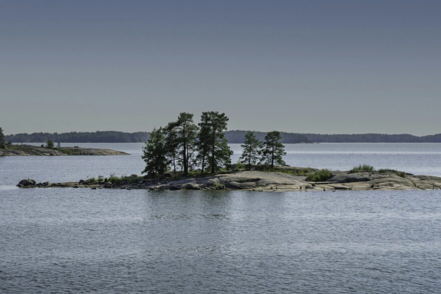 M&auml;ntyjen peitt&auml;m&auml; luoto tyynell&auml; merell&auml;