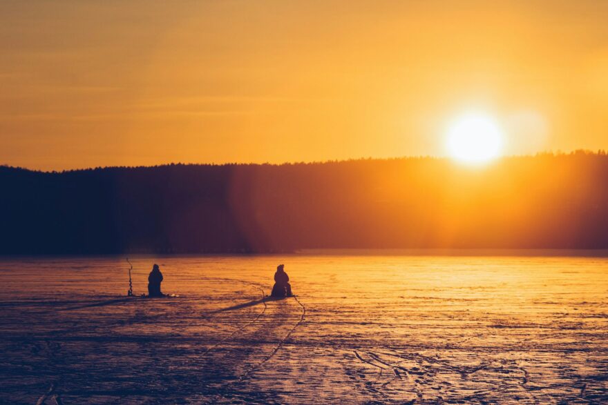 Pilkkij&ouml;it&auml; j&auml;&auml;tyneell&auml; j&auml;rvell&auml; talvisessa auringonlaskussa