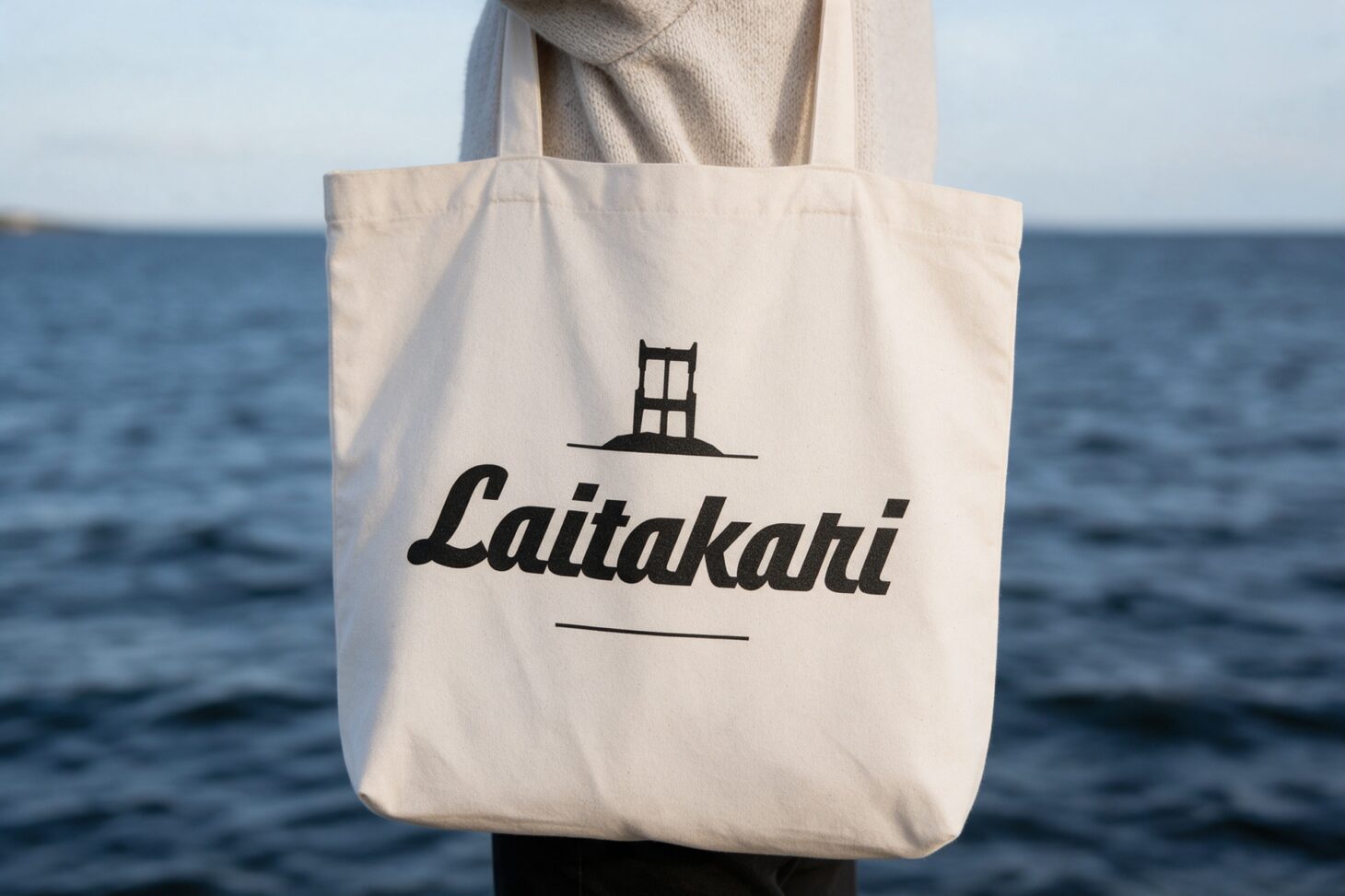 Laitakari ry:n logo kangaskassissa meren rannalla