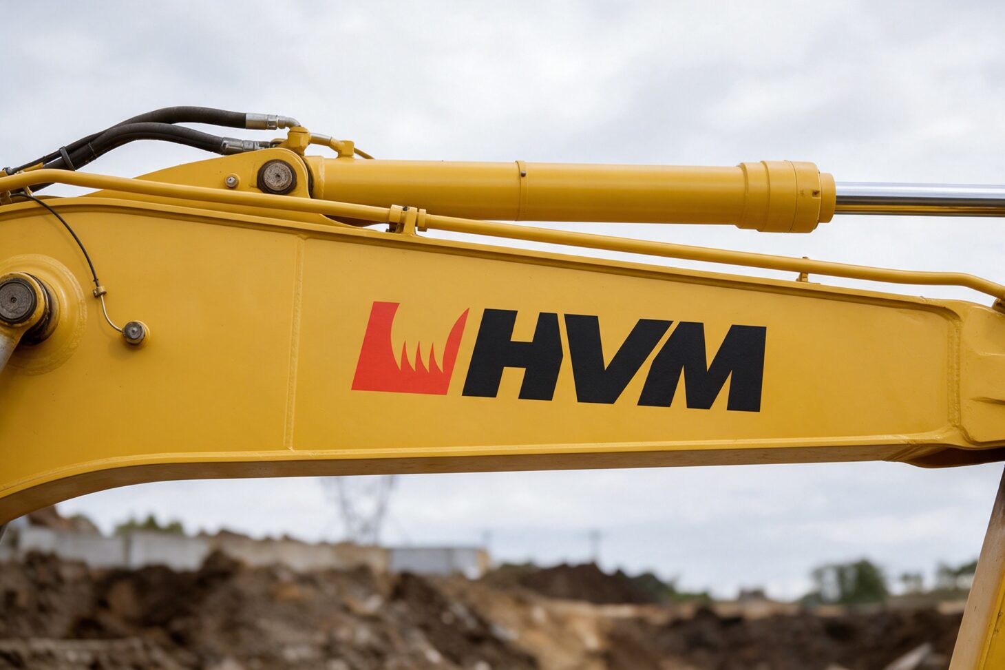 HVM:n logo kaivinkoneen puomissa