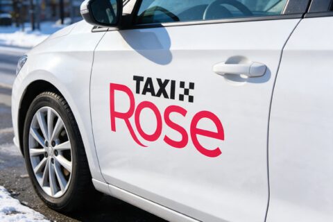 Taxi Rosen logo valkoisen taksin ovessa