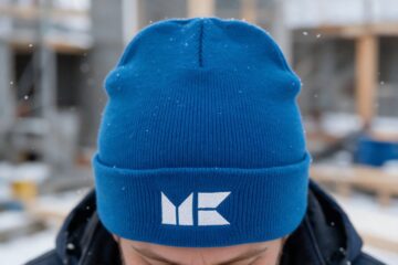 Rakennusliike M. Kurtin tunnus brodeerattuna pipoon